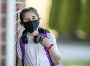 Student wearing a mask on her way to school.